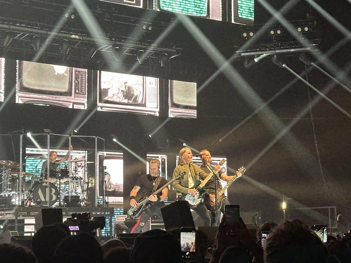 Alter Bridge on stage under criss-crossing spotlights